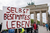 Ein Protestschild auf einer Demo vor dem Brandenburger Tor, es trägt die Aufschrift: "Selbstbestimmtes Leben".