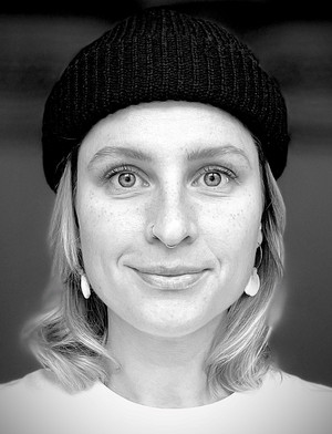 Porträt blonder junger Frau mit dunkler Mütze 